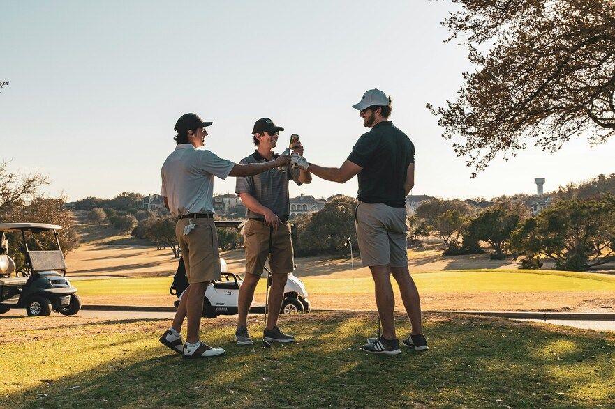 Golf buddies having a drink on the course during a sunny day
