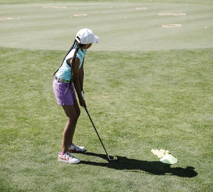 Golf girl practicing her chipping