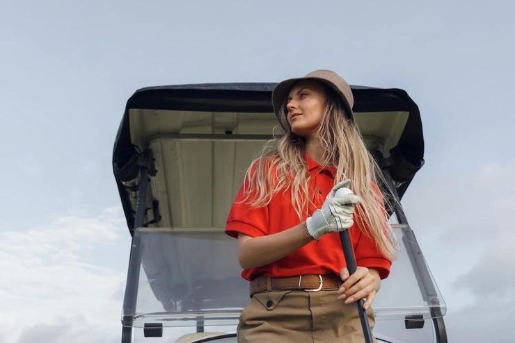 Golfer girl with a bob hat and a red polo